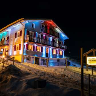 La Gasthaus Alpina è illuminata di sera in inverno